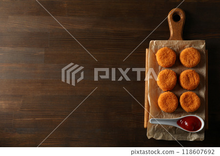 Fried mozzarella on a wooden board on a dark background 118607692