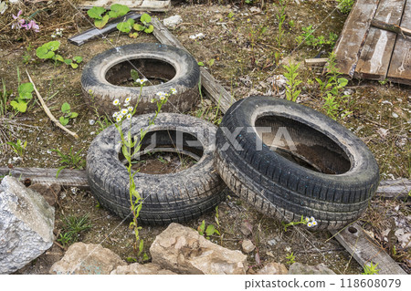 Environment and ecology. Tires from cars and construction debris dumped on the ground 118608079