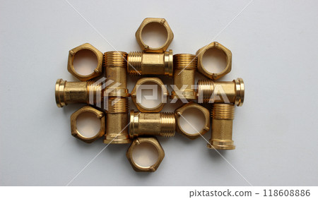 Plumbing Accessories. Water Meter Fittings With Union Nuts Laid Out In Order On White Surface Top View Plumbing Accessories. Water Meter Fittings With Union Nuts Laid Out In Order On White Surface Top View 118608886