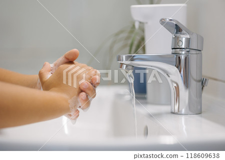 Little girl wash hand after school. White and clean bathroom. Automatic soap dispenser in the bathroom.  118609638