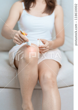 Arthritis and Muscle Pain Relief Cream concept. woman having knee ache and muscle pain due to Runners Knee or Patellofemoral Pain Syndrome, osteoarthritis, rheumatism and Patellar Tendinitis 118610002