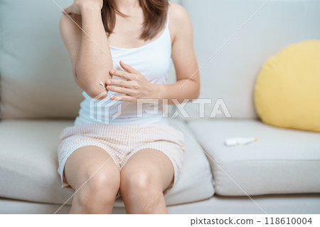 Arthritis and Muscle Pain Relief Cream concept. Woman having elbow ache at home, muscle pain due to lateral epicondylitis or tennis elbow. injury, Health and medical concept 118610004