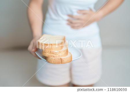 Gluten intolerance, Gluten free and celiac disease or wheat allergy concept. woman hold Bread and having abdominal pain after eat gluten. stomach ache, Nausea, Bloating, Gas, Diarrhea and Skin rash Gluten intolerance, Gluten free and celiac disease or wheat allergy concept. woman hold Bread and having abdominal pain after eat gluten. stomach ache, Nausea, Bloating, Gas, Diarrhea and Skin rash 118610030