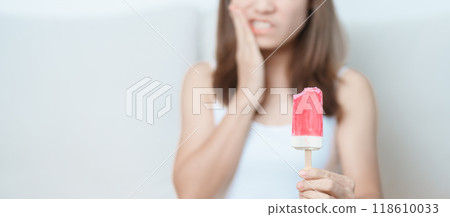 Teeth Sensitive to Cold concept. woman hold Ice cream and having toothache and pain after eat. Tooth Decay or Gum Disease, Grinding Teeth and Stress, Exposed Nerve Roots, Crack and Receding Gums 118610033