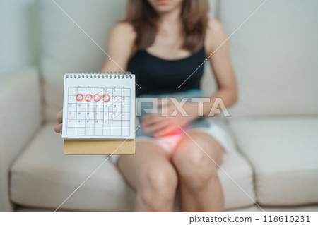 Menstruation period cycle of monthly and Stomachache concepts. woman having abdomen pain with hot water bottle and calendar, illness female suffer from premenstrual ache and body Health problem Menstruation period cycle of monthly and Stomachache concepts. woman having abdomen pain with hot water bottle and calendar, illness female suffer from premenstrual ache and body Health problem 118610231