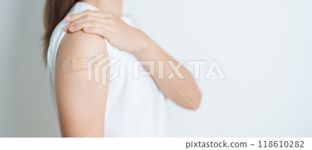 Woman with bandage after receiving vaccine. Vaccination and Immunization for Influenza, HPV, Zoster, IPD, DTP or Diphtheria, Tetanus and Pertussis, MMR, Hepatitis B, Covid  and Varicella vaccine 118610282