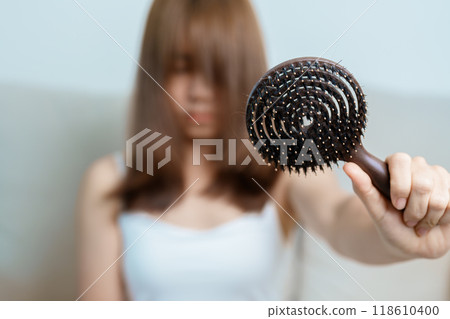 Hair loss problem, Balding , Beauty treatments and health care concepts asian woman holding holding comb with hair loss, young female hold hairbrush and brushing with fall hair from scalp Hair loss problem, Balding , Beauty treatments and health care concepts asian woman holding holding comb with hair loss, young female hold hairbrush and brushing with fall hair from scalp 118610400