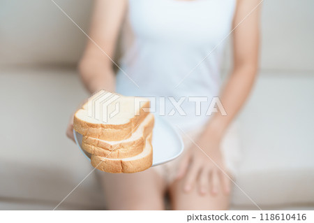 Bread eating and Daily Routine concept. Young woman Hand holding sliced whole grain bread in the morning at home 118610416