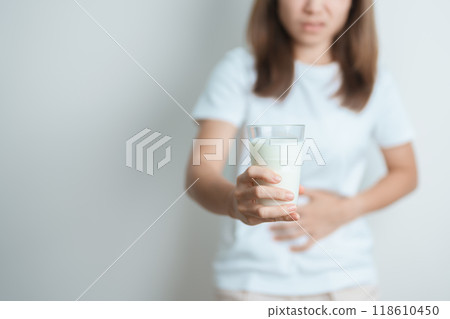 Lactose intolerance and Milk allergy concept. woman hold Milk glass and having abdominal cramps and pain when drink Cow Milk. Symptom stomach ache, Dairy intolerant, Nausea, Bloating, Gas and Diarrhea 118610450