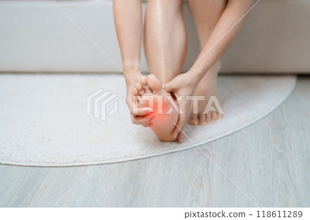 woman having barefoot pain at home. Foot ache due to Plantar fasciitis and waking longtime. Health and medical concept 118611289