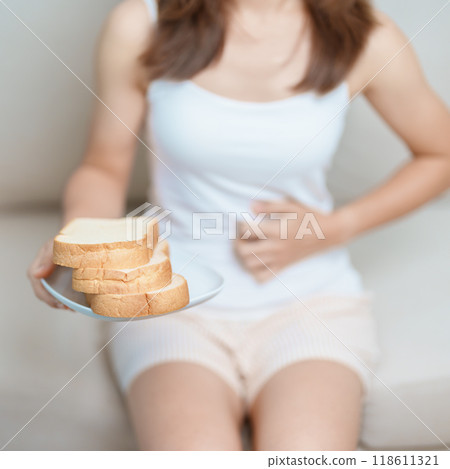 Gluten intolerance, Gluten free and celiac disease or wheat allergy concept. woman hold Bread and having abdominal pain after eat gluten. stomach ache, Nausea, Bloating, Gas, Diarrhea and Skin rash 118611321