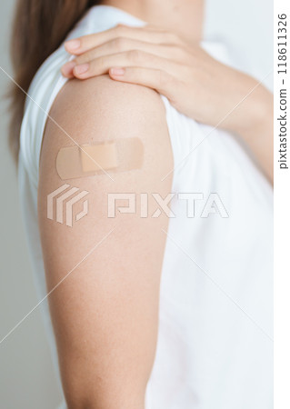 Woman with bandage after receiving vaccine. Vaccination and Immunization for Influenza, HPV, Zoster, IPD, DTP or Diphtheria, Tetanus and Pertussis, MMR, Hepatitis B, Covid  and Varicella vaccine 118611326