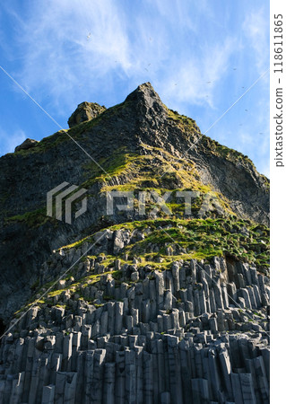 Towering rock against blue sky. View from below 118611865