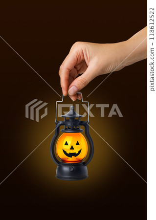 Halloween pumpkin lamp in a woman's hand. Halloween autumn concept. On black background copy space vertical banner Halloween pumpkin lamp in a woman's hand. Halloween autumn concept. On black background copy space vertical banner 118612522
