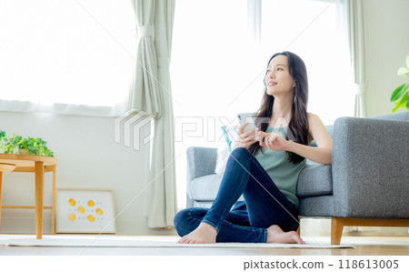 Young woman looking at her smartphone in the living room 118613005