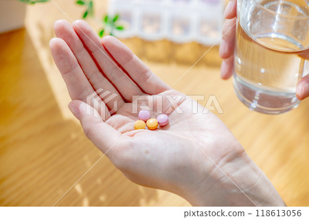 A young woman drinking supplements in the living room 118613056