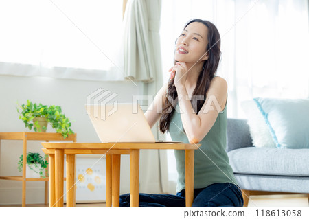 使用個人計算機的婦女在屋子裡 使用個人計算機的婦女在屋子裡 118613058