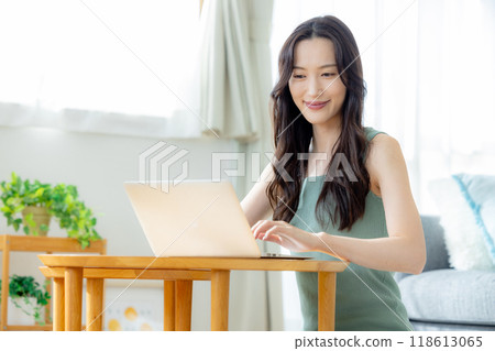 A woman using a personal computer in a room A woman using a personal computer in a room 118613065