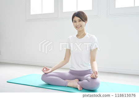 Middle-aged woman doing zazen yoga, looking at camera 118613076