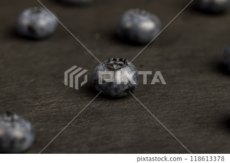 blueberries scattered on a black slate board blueberries scattered on a black slate board 118613378
