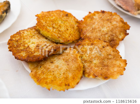 Fried grated potato pancakes with sour cream on white plate 118615616