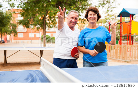 Mature couple showing victory near table tennis 118615680