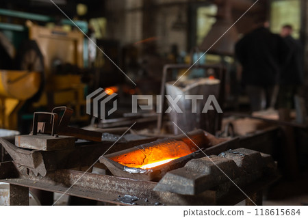 Mold with molten metal in the foundry workshop of metallurgical plant 118615684