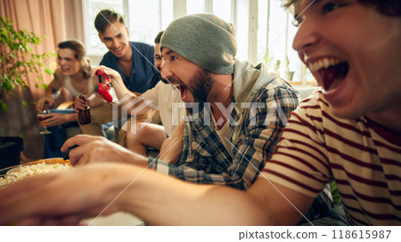 With hands gripping controllers and eyes locked on screen, this group of friends all in, sharing laughs, drinks, and thrill of competition. With hands gripping controllers and eyes locked on screen, this group of friends all in, sharing laughs, drinks, and thrill of competition. 118615987