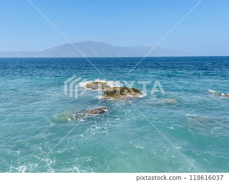 Rocky beach and crystal turquoise water of Ionian Sea in Albania. 118616037