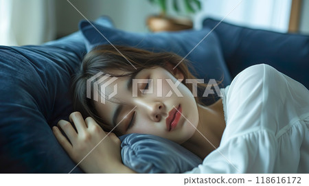 一位年輕女子在藍色沙發上小睡的睡臉 118616172