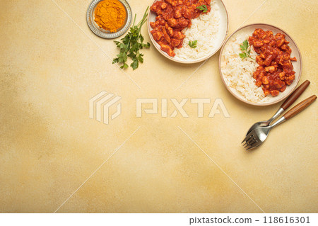 Indian chicken curry with rice and turmeric on yellow background with copy space top view Indian chicken curry with rice and turmeric on yellow background with copy space top view 118616301