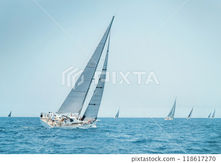 Sailboats races near Brindisi under blue sky. Crew members working together on deck 118617270