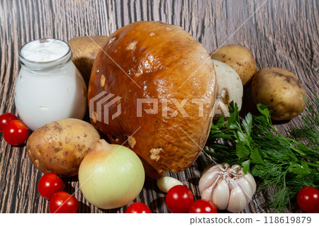 Roast mushroom Boletus edulis. Ingredients for cooking roast: large mushroom Boletus edulis, potatoes, sour cream, onion, garlic, tomatoes Roast mushroom Boletus edulis. Ingredients for cooking roast: large mushroom Boletus edulis, potatoes, sour cream, onion, garlic, tomatoes 118619879