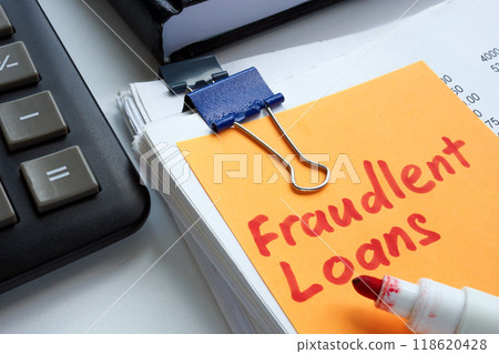 Stack of papers with a sticky note reading fraudulent loans. 118620428
