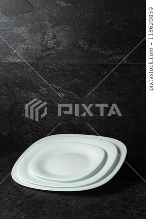 Empty white plates on a black stone background with copy space. 118620839