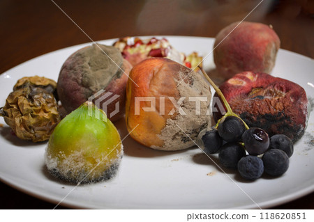 Spoiled and rotten tropical fruits - lychee, peach, fig on a white plate on a wooden table. Concept of the problem of hunger in some regions of the planet and overconsumption in others Spoiled and rotten tropical fruits - lychee, peach, fig on a white plate on a wooden table. Concept of the problem of hunger in some regions of the planet and overconsumption in others 118620851