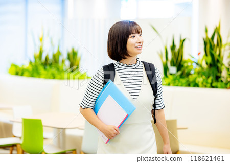 Female university student holding a file. Photo courtesy of Denpa Gakuen, Tokyo Electronics College. 118621461