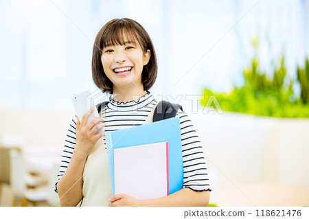 Smiling university student operating a smartphone in a university classroom. Photo courtesy of Denpa Gakuen, Tokyo Electronics College. 118621476
