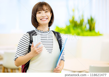 Smiling university student operating a smartphone in a university classroom. Photo courtesy of Denpa Gakuen, Tokyo Electronics College. 118621477