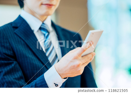 A businessman operating a smartphone. Photo courtesy of Denpa Gakuen, Tokyo Electronics College. A businessman operating a smartphone. Photo courtesy of Denpa Gakuen, Tokyo Electronics College. 118621505