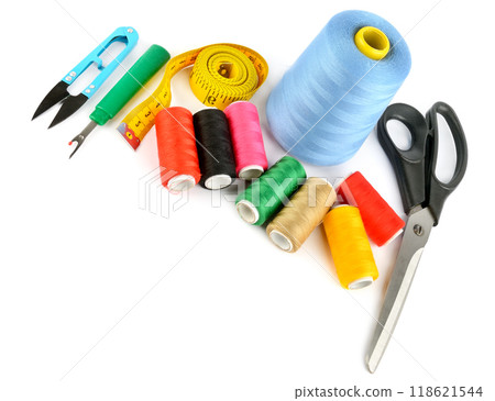Sewing supplies (thread, scissors and measuring tape) isolated on a white. Free space for text. 118621544
