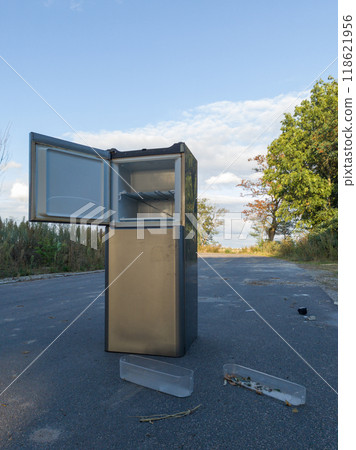 Discarded refrigerator with open door left on roadside 118621956