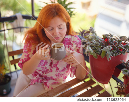 Woman drinking tea and relaxing at the balcony. Have rest after work 118622064