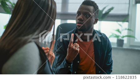 Aggressive man shouts at his girlfriend on counseling session with family psychotherapist 118622835