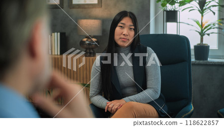 Asian young woman talks about family conflict with psychotherapist 118622857