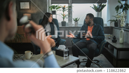 Back view of therapist listening to young family on counseling session 118622862
