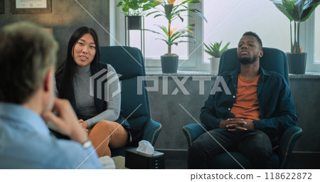 Multiethnic couple sit on chairs, discuss relationship problems with psychologist Multiethnic couple sit on chairs, discuss relationship problems with psychologist 118622872