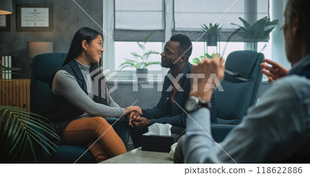 Happy multiethnic couple sit on chairs hand in hand on couples therapy 118622886