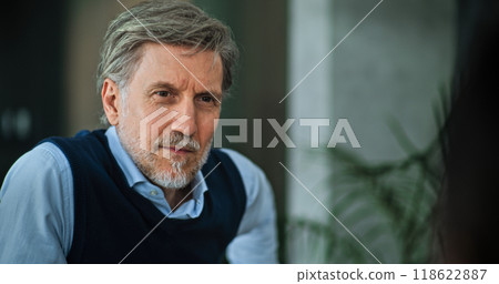 Mature family psychologist listens to patients during counseling session Mature family psychologist listens to patients during counseling session 118622887