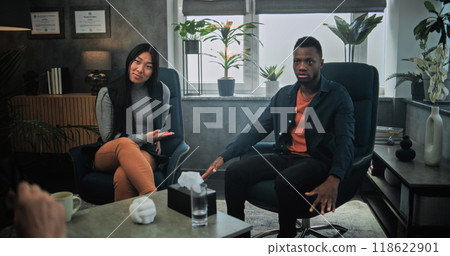 Aggressive African American man yells at his Asian girlfriend during counseling session Aggressive African American man yells at his Asian girlfriend during counseling session 118622901